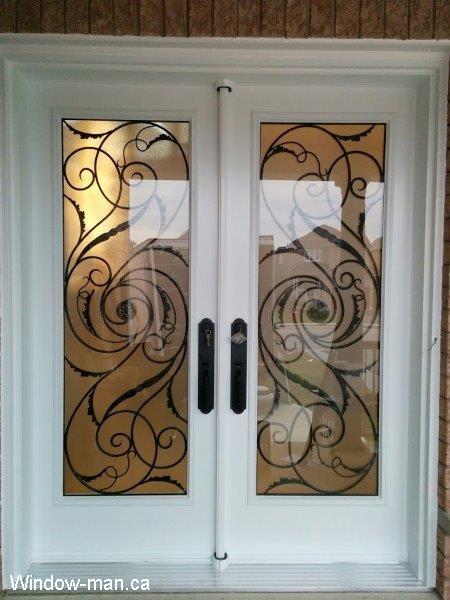 Double steel insulated front entry doors. White. Full wrought iron glass door inserts. Port Union iron design
